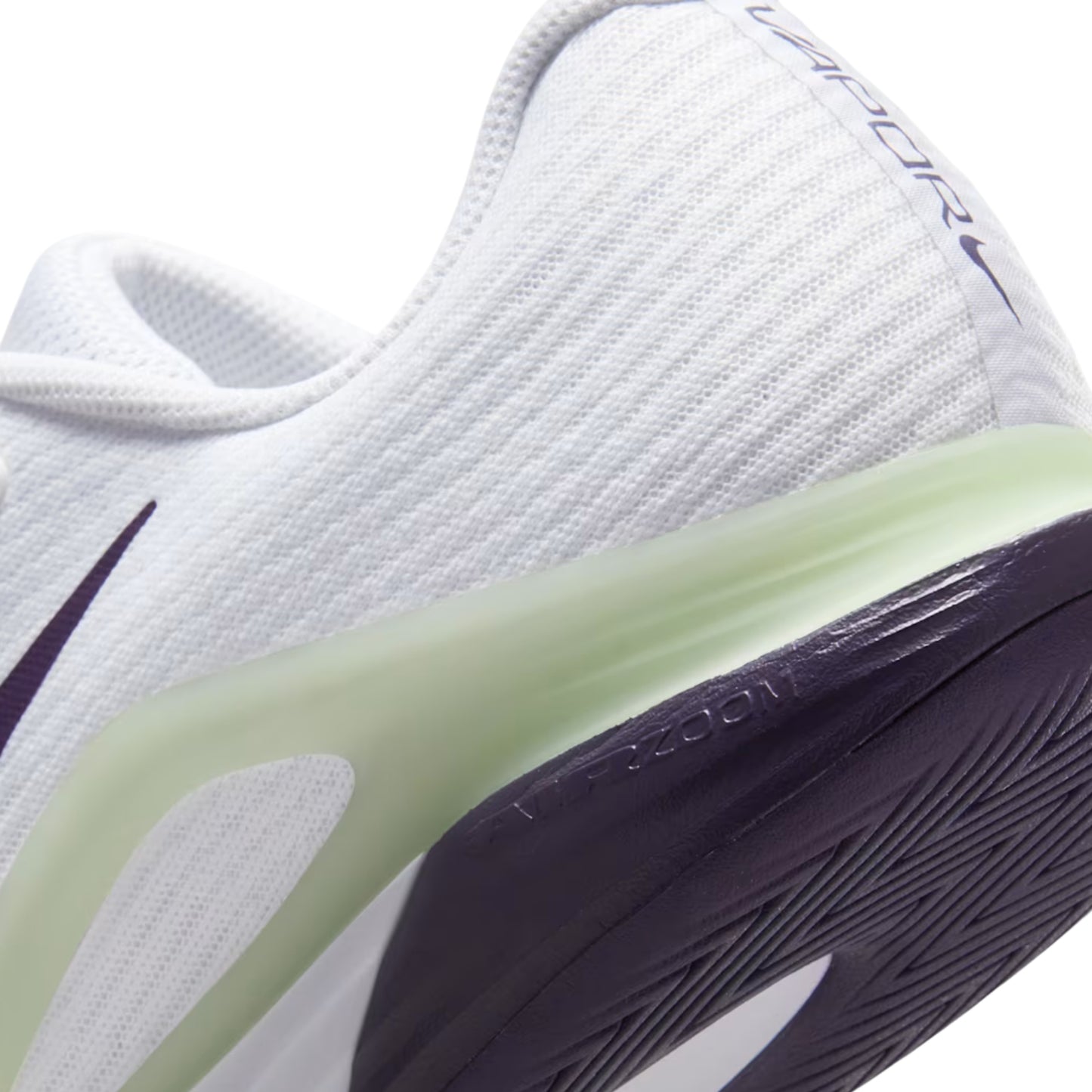 Close-up of a white tennis shoe with navy and green sole