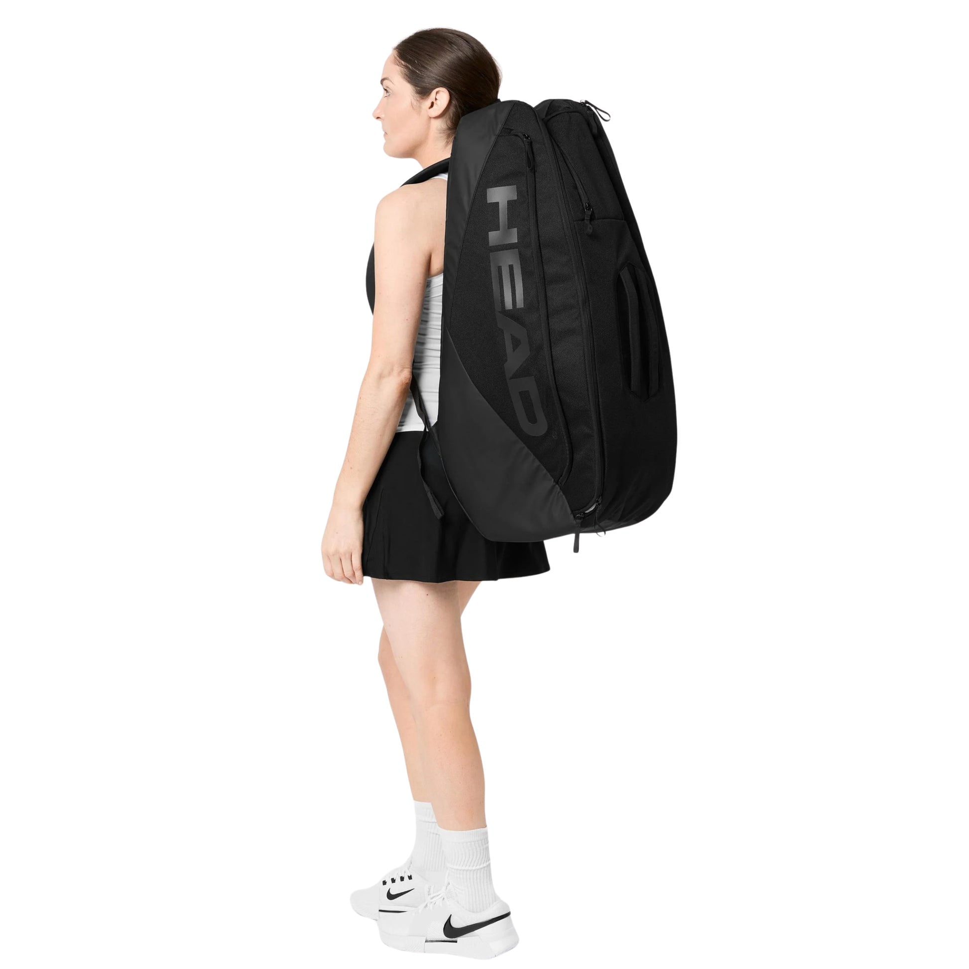 Person wearing a black Head racket bag on a white background