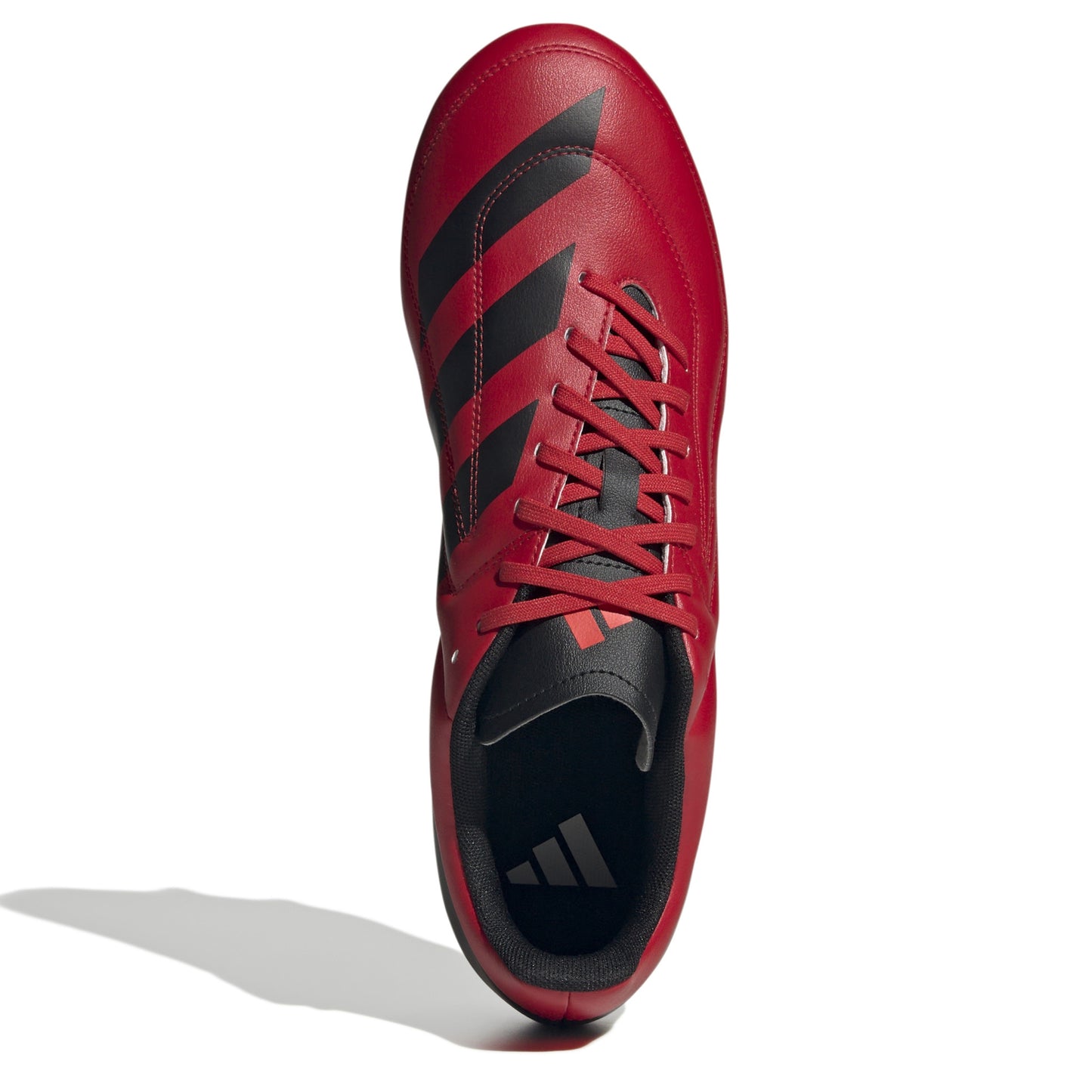 Top view of red and black rugby boot with white sole on a white background