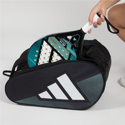 Paddle and racket in a black Adidas bag on a light gray background