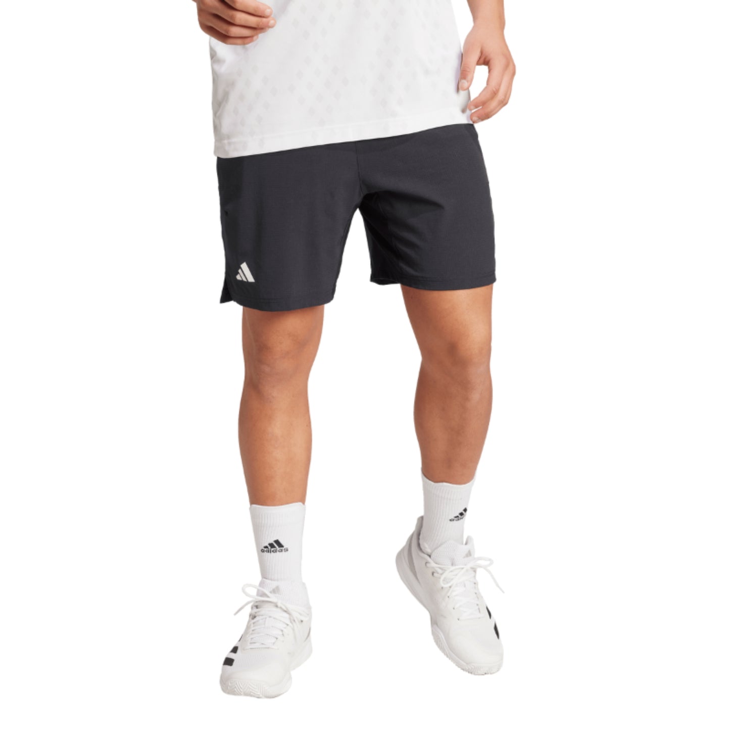 Person wearing black Adidas shorts on a white background