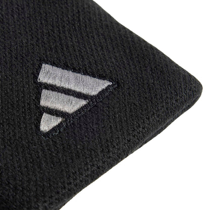Close-up of a black textured wristband with a silver embroidered geometric logo on a white background.