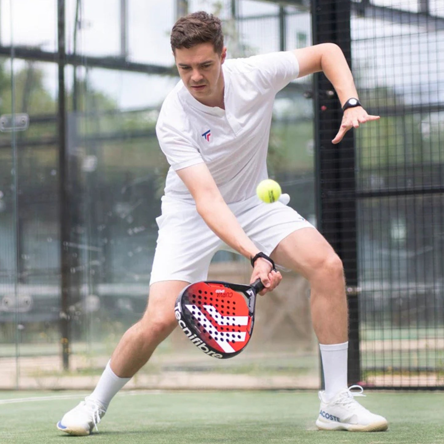 Man playing padel on a court with a racket and ball