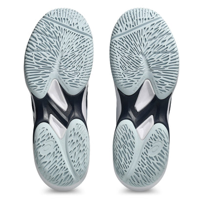 Close-up of a pair of tennis shoes with tread pattern soles on a white background