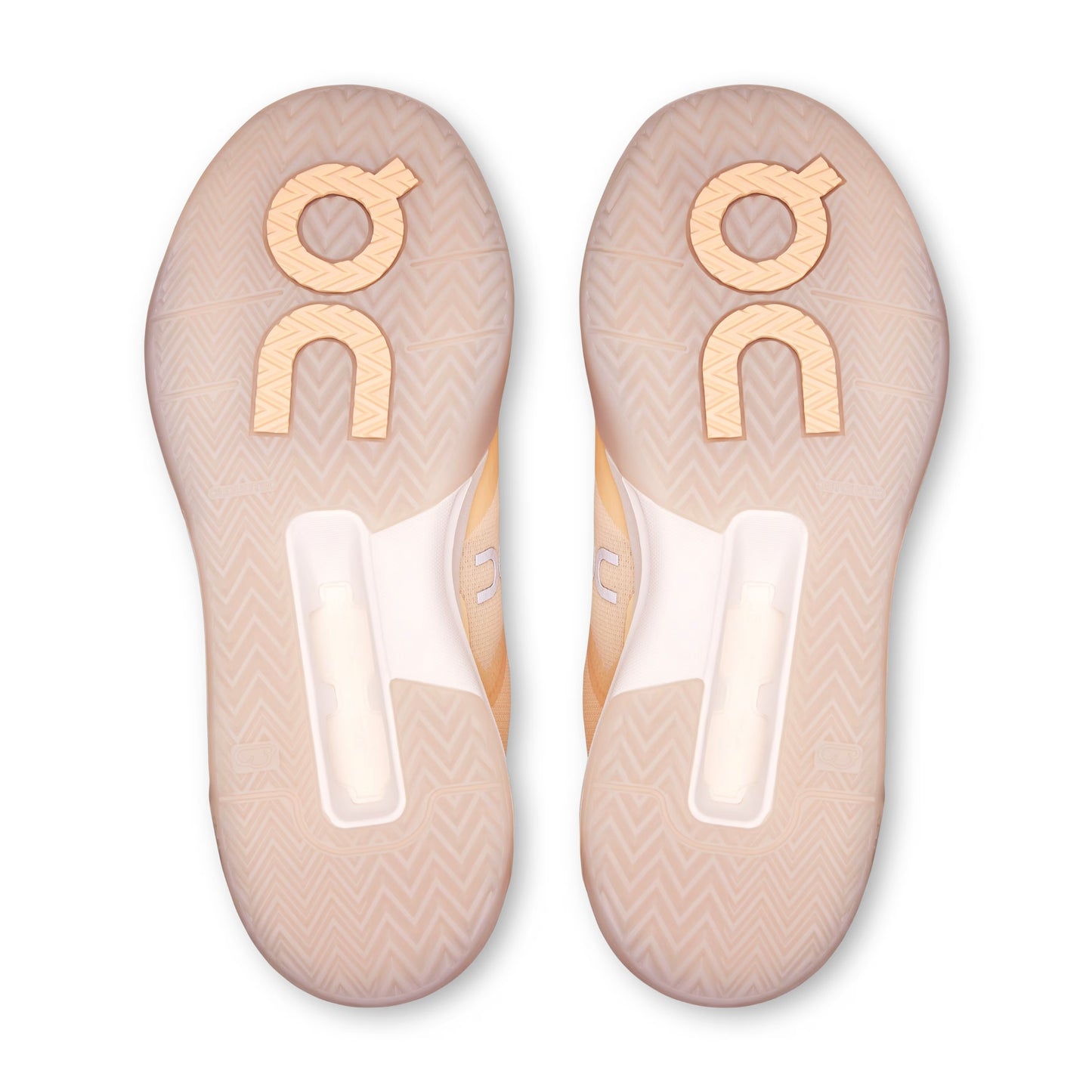 Top-down view of a pair of On shoe soles in a pale peach-beige color with a chevron pattern and a large metallic gold 'on' logo on each.
