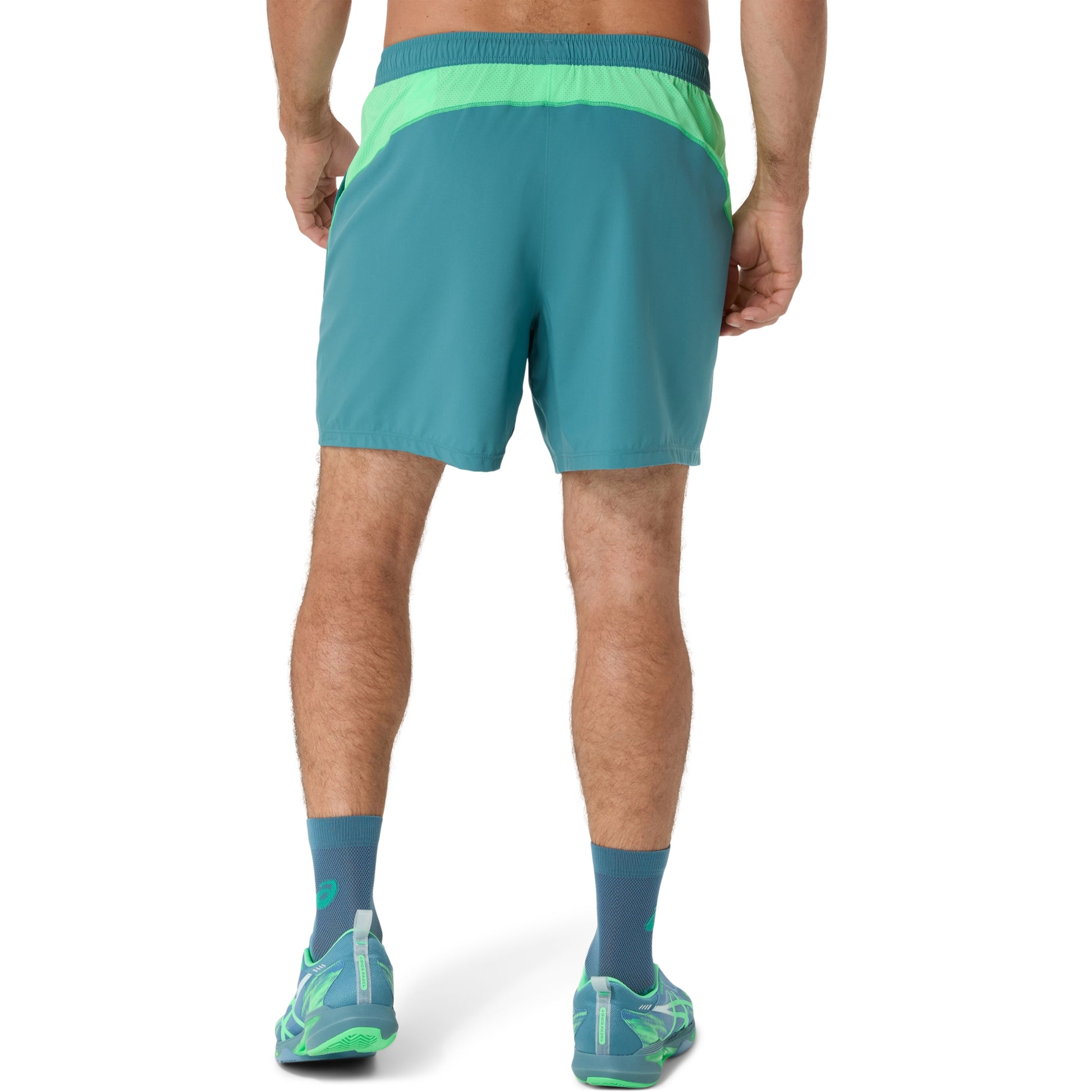 Person wearing teal shorts with green accents on a white background