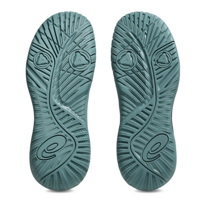 Green Asics shoe sole with a tread pattern with the Asics logo on a white background