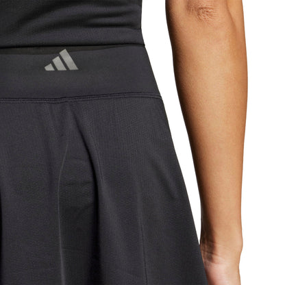 A woman wearing a black adidas skirt on a white background