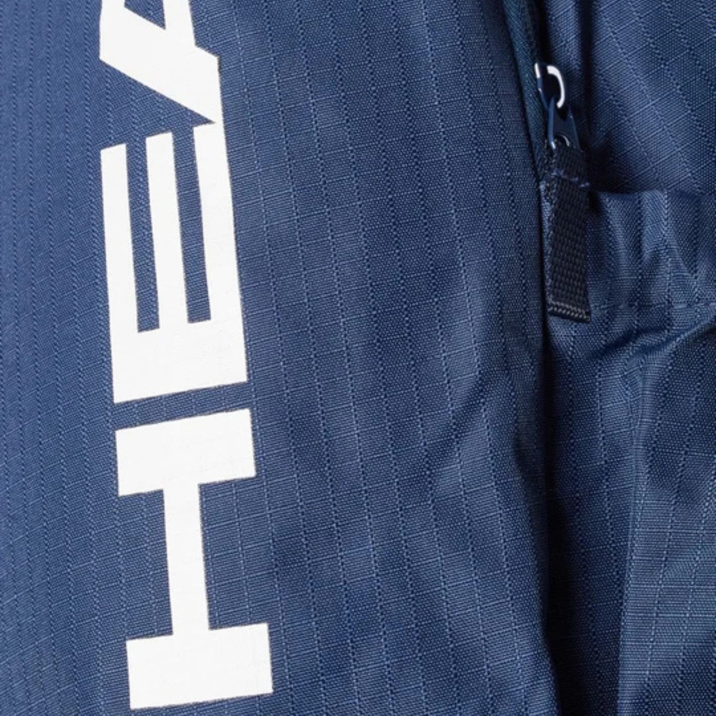 Close-up of a navy blue backpack with a white logo on the side