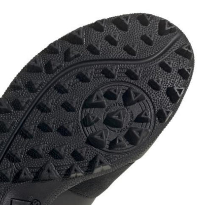 Close-up of a black shoe sole with a brand logo on a white background