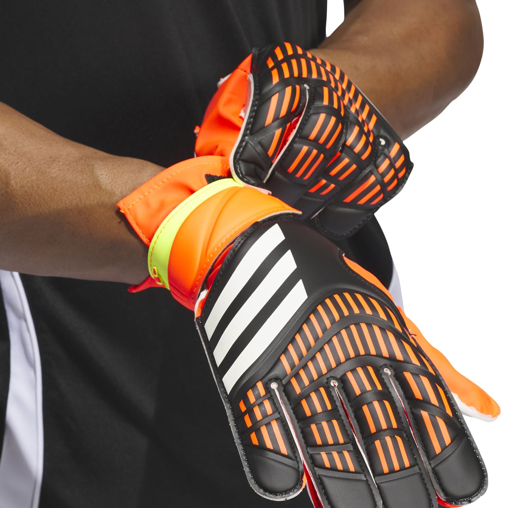 Close-up of orange and black soccer goalkeeper gloves with Adidas logo on a white background