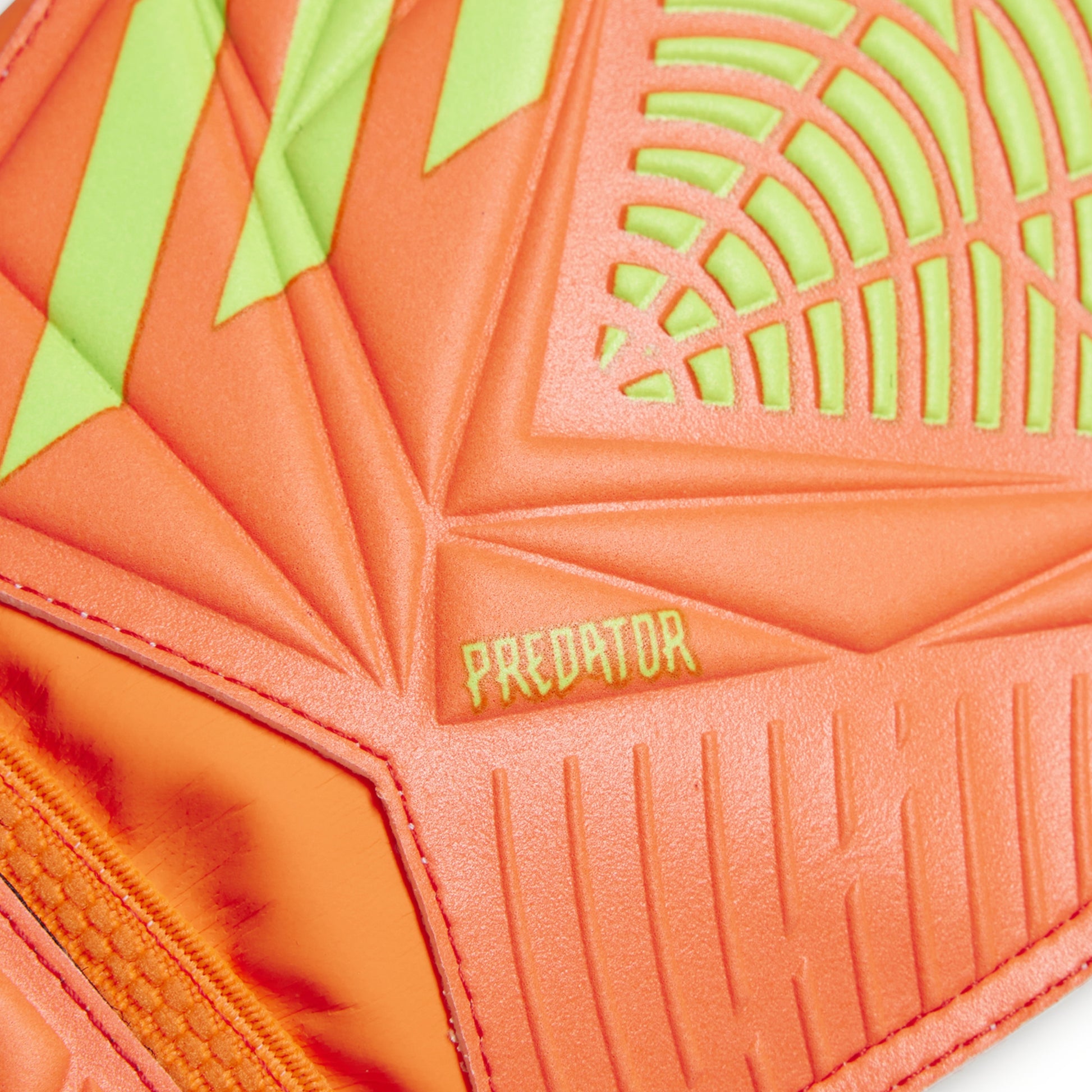 Close-up of an orange and green soccer ball with 'Predator' branding.