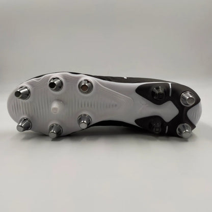 Close-up of a rugby boot with metal studs on a gray background