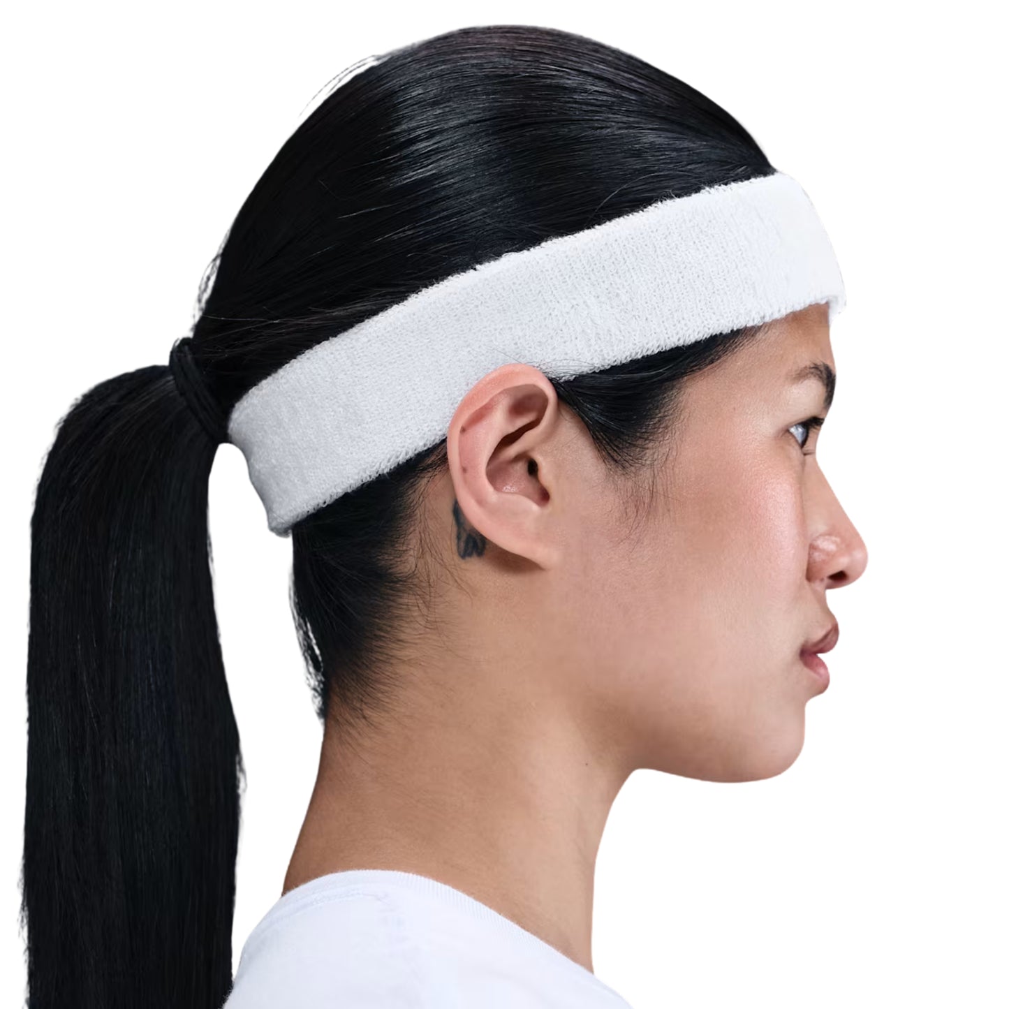 Woman wearing a white headband with her hair in a ponytail on a white background