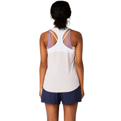 Person wearing a light rose tank top with thin straps and navy shorts on a white background