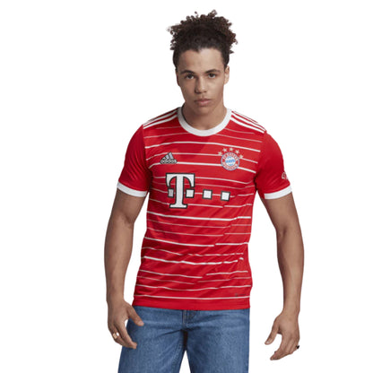 Person wearing a red and white striped soccer jersey with Adidas logo on a white background