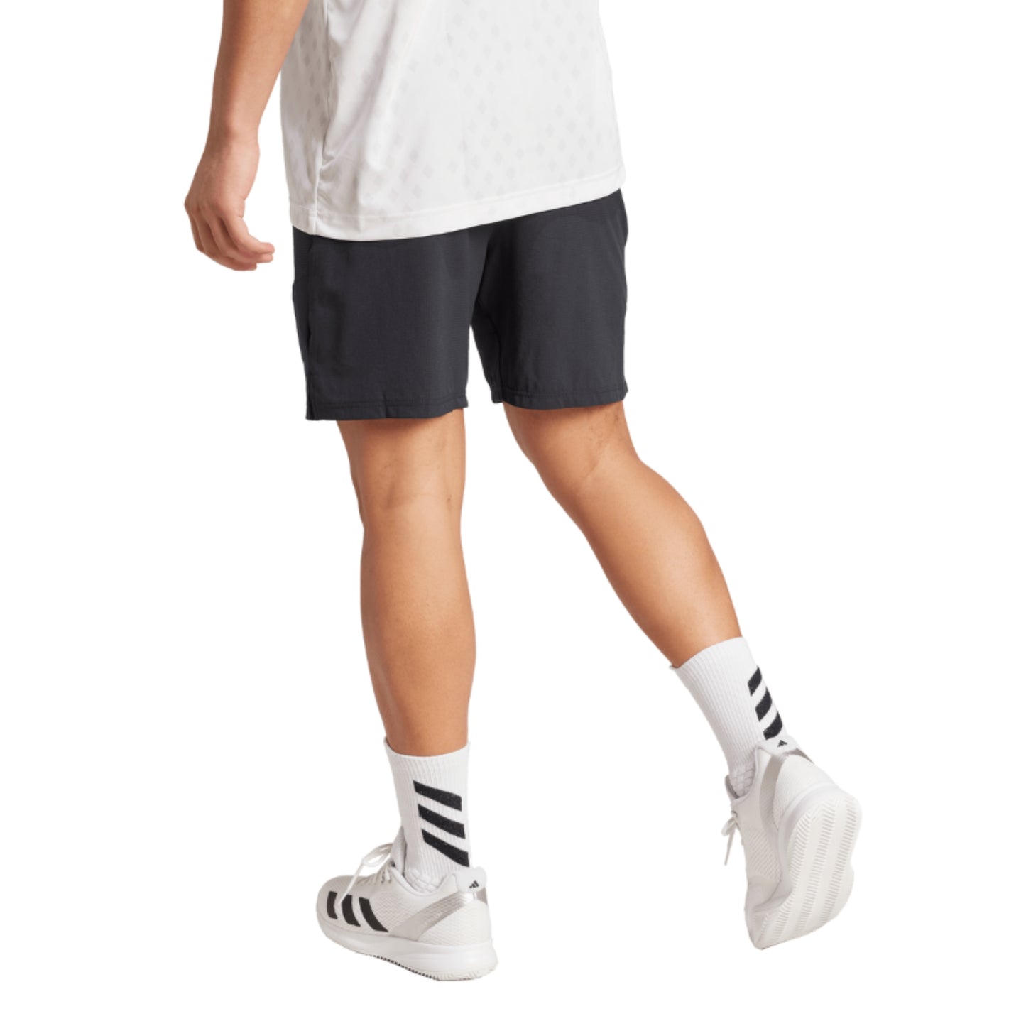 Person wearing black shorts, white shirt, and white sneakers with black stripes on a white background