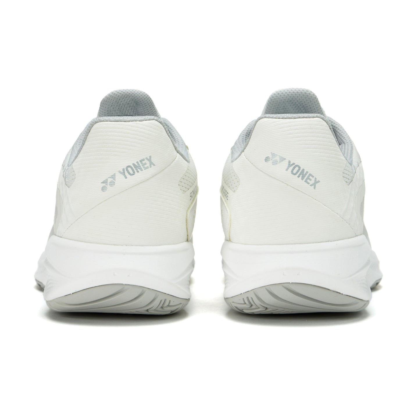 White Yonex tennis shoes shown from the back on a white background