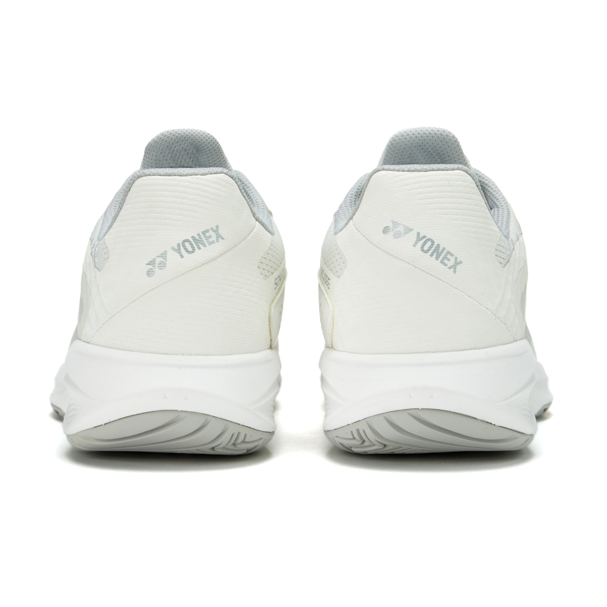 White Yonex tennis shoes shown from the back on a white background