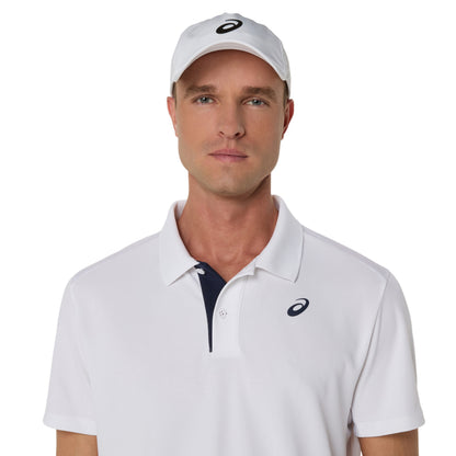 Man wearing a white Asics polo shirt and cap with a logo on a white background