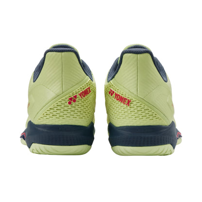Green and navy Yonex shoes on a white background