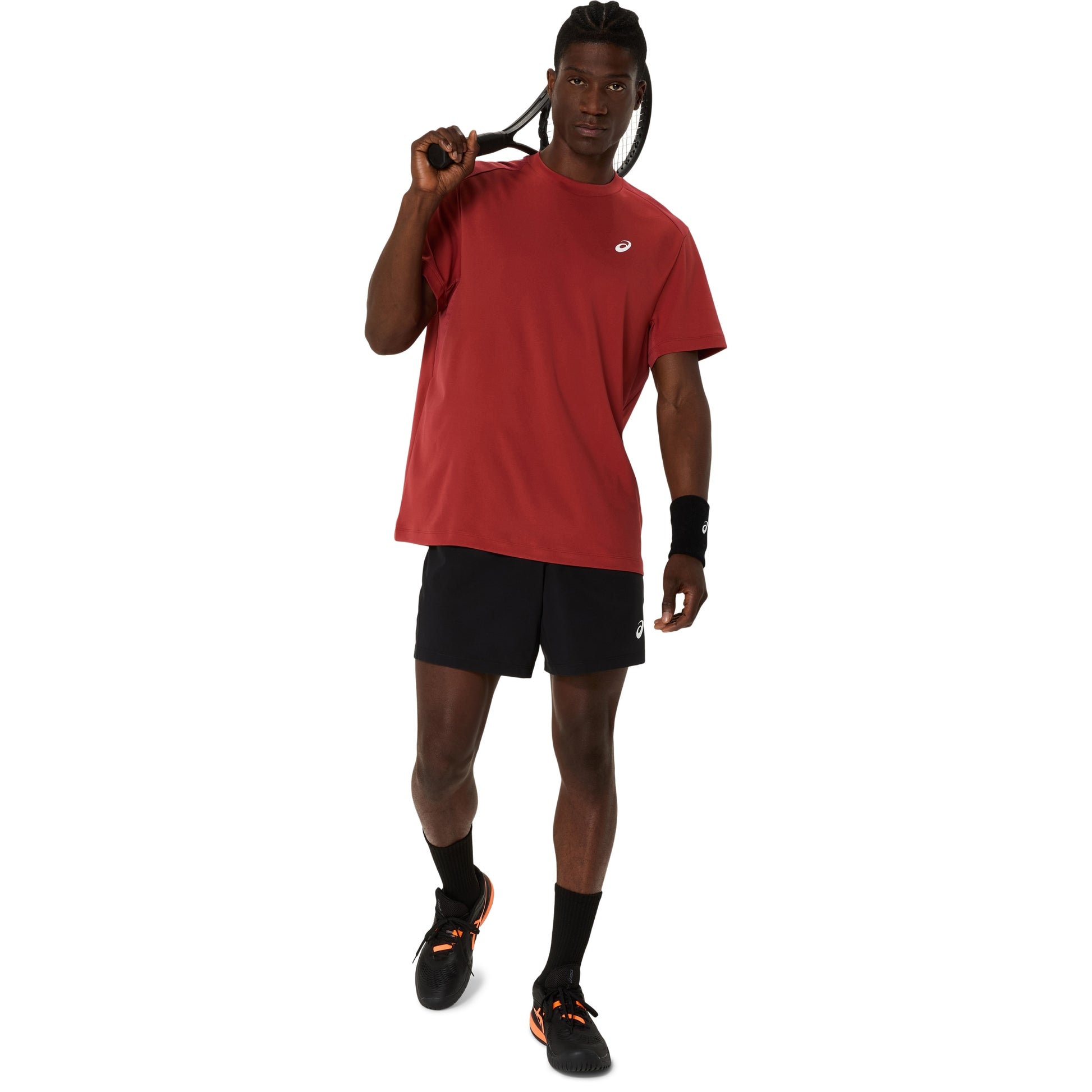 A man modeling a red short-sleeve athletic t-shirt and black athletic shorts, standing against a solid white background.