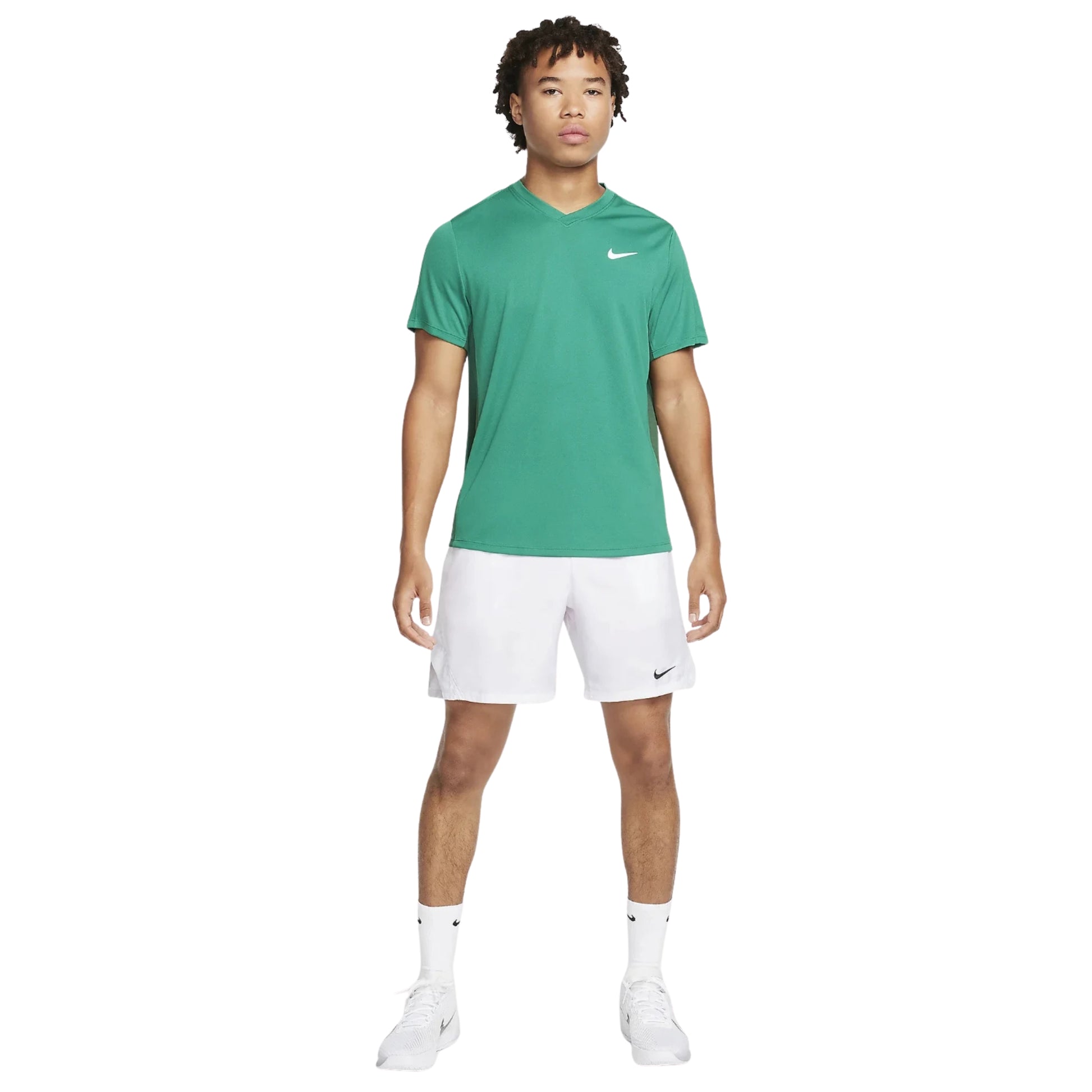 Person wearing a green Nike t-shirt and white shorts on a white background