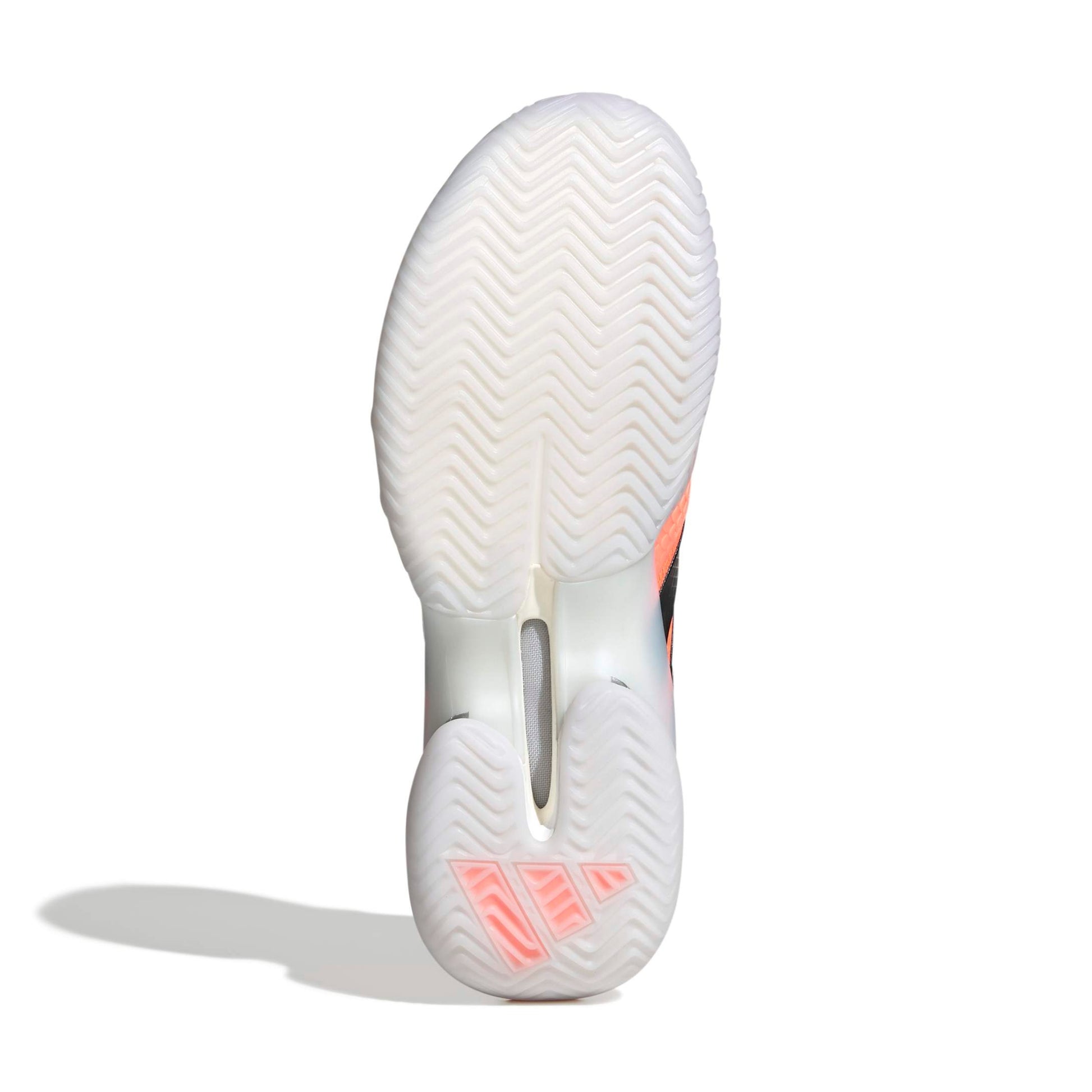 Close-up of a white tennis shoe sole with light orange accents on a white background