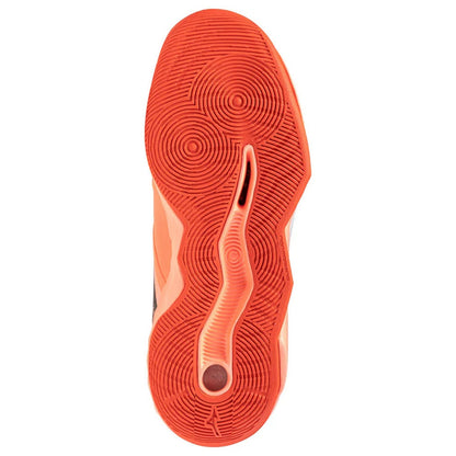 A close-up top-down view of a shoe's textured orange-red outsole, showing circular tread patterns and a central channel, on a plain white background.