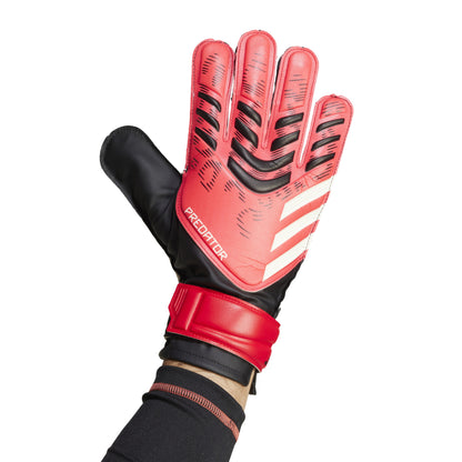 Red and black Adidas soccer glove with 'Predator' branding on a white background