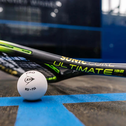 Dunlop squash racket and ball on a court surface with a blurred background