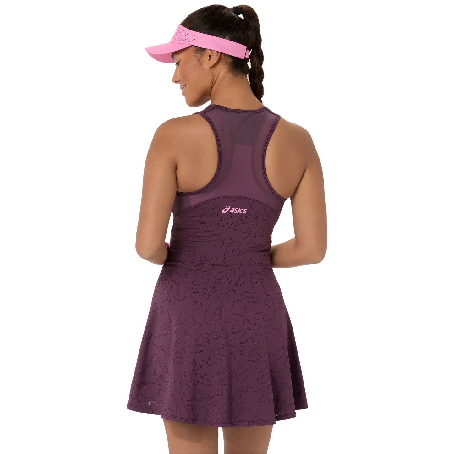 A woman shown from the back wearing an ASICS athletic dress in a deep plum purple with a matching pink visor. The dress features a subtle wavy pattern and a small pink ASICS logo on the upper back.