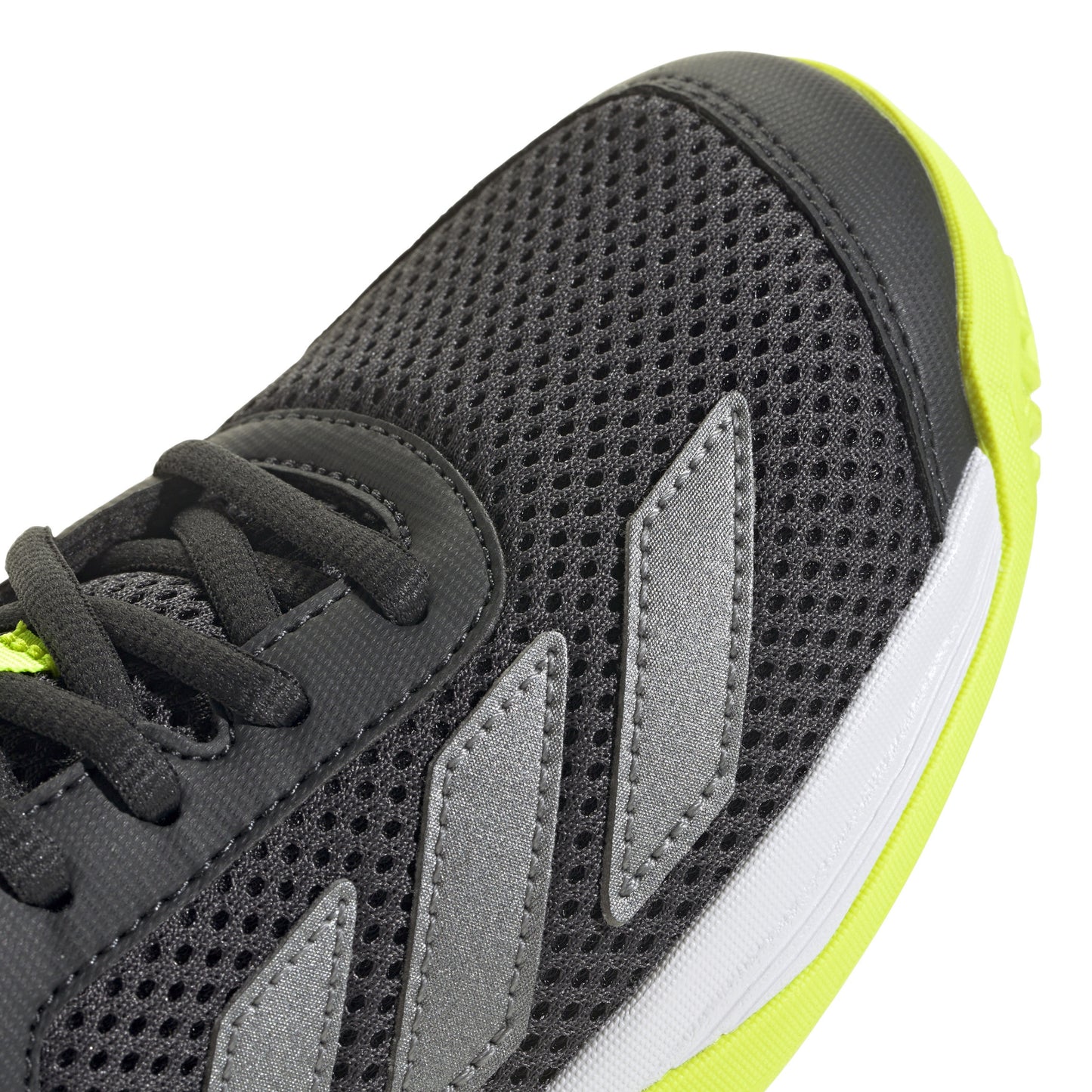 Black Adidas tennis shoe with black laces and yellow sole on a white background