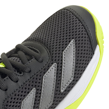 Black Adidas tennis shoe with black laces and yellow sole on a white background