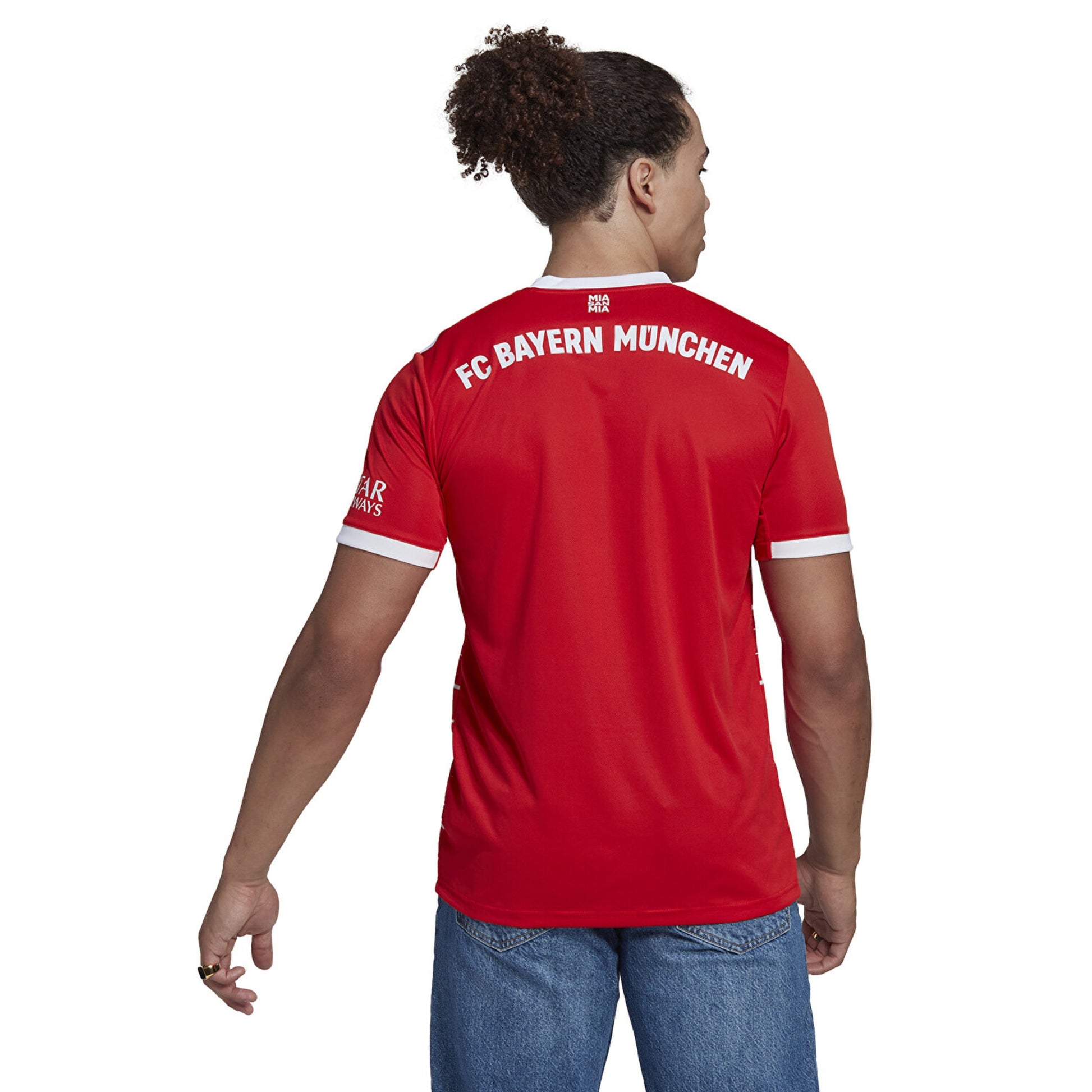 Person wearing a red Adidas FC Bayern Munich jersey on a white background