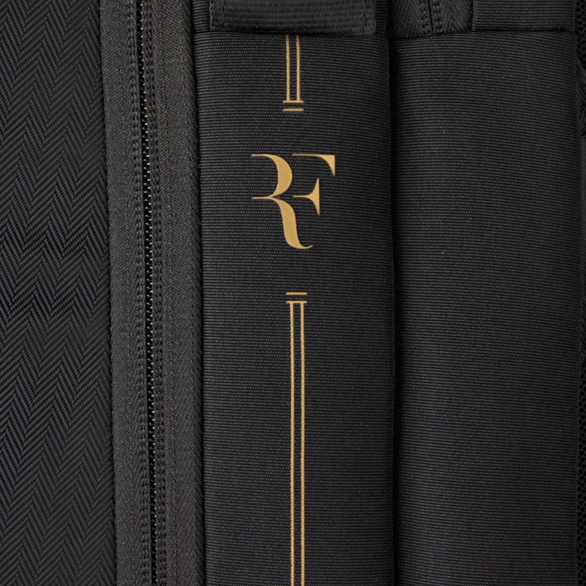 Close-up of a black bag with gold logo and text