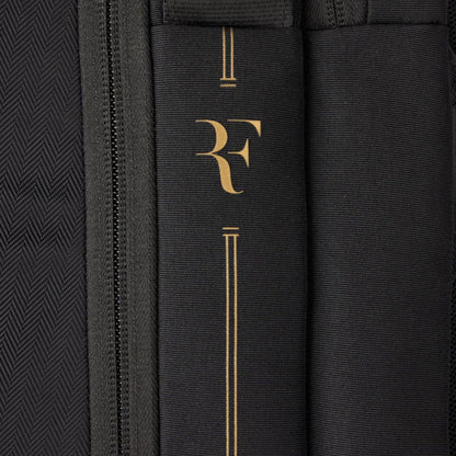 Close-up of a black bag with gold logo and text