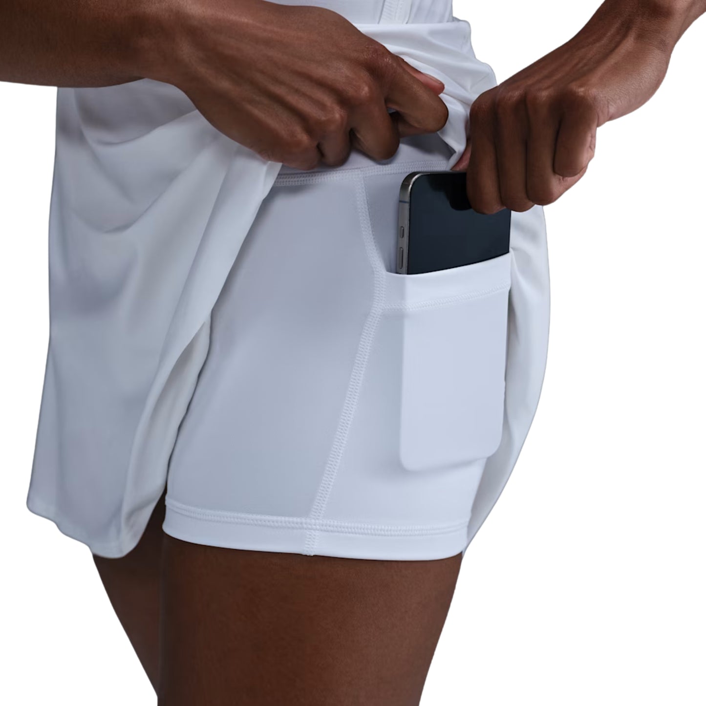 Person wearing white skirt with a pocket, holding a smartphone.