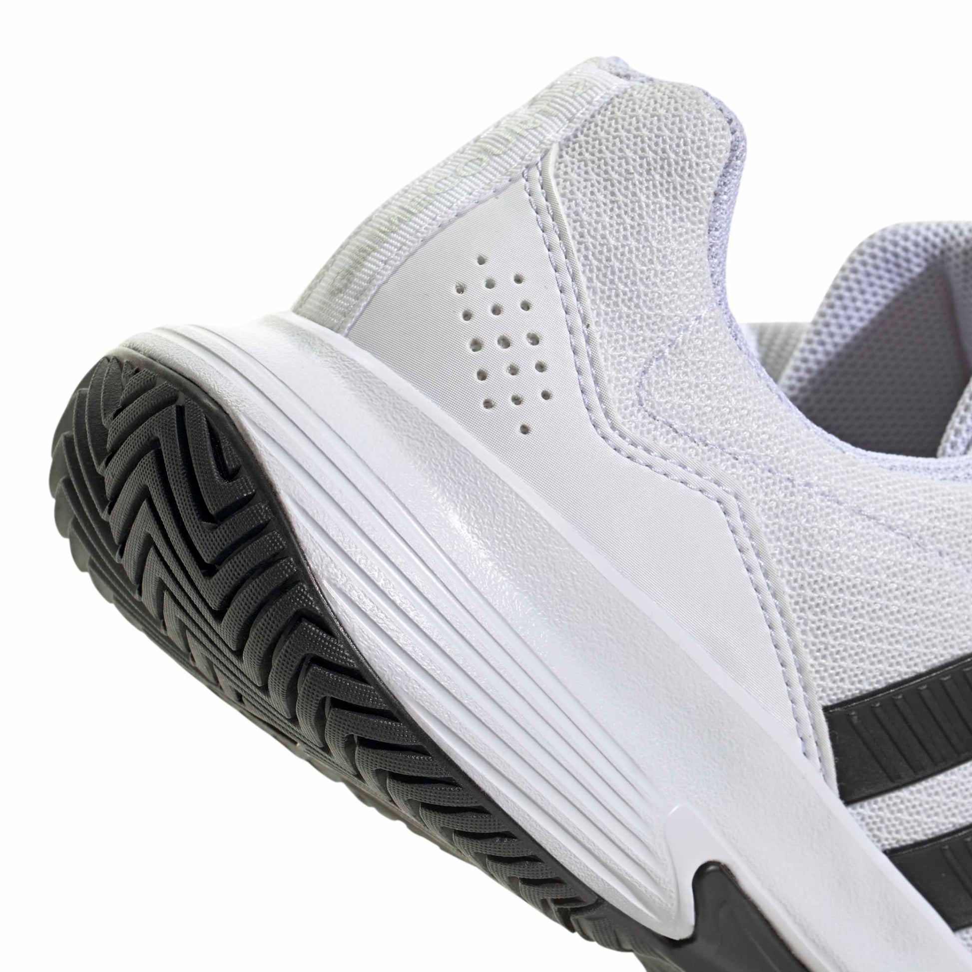 White tennis shoe with black sole and stripes on a white background