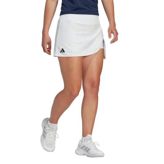 Person wearing a white Adidas tennis skirt on a white background