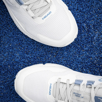White padel shoes with 'HEAD' branding on a blue textured surface