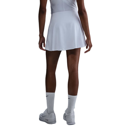 Person wearing a white tennis skirt, white socks, and white shoes on a white background