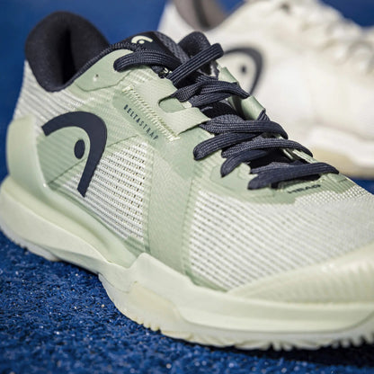 Light green Head padel shoe with dark laces on a blue textured surface