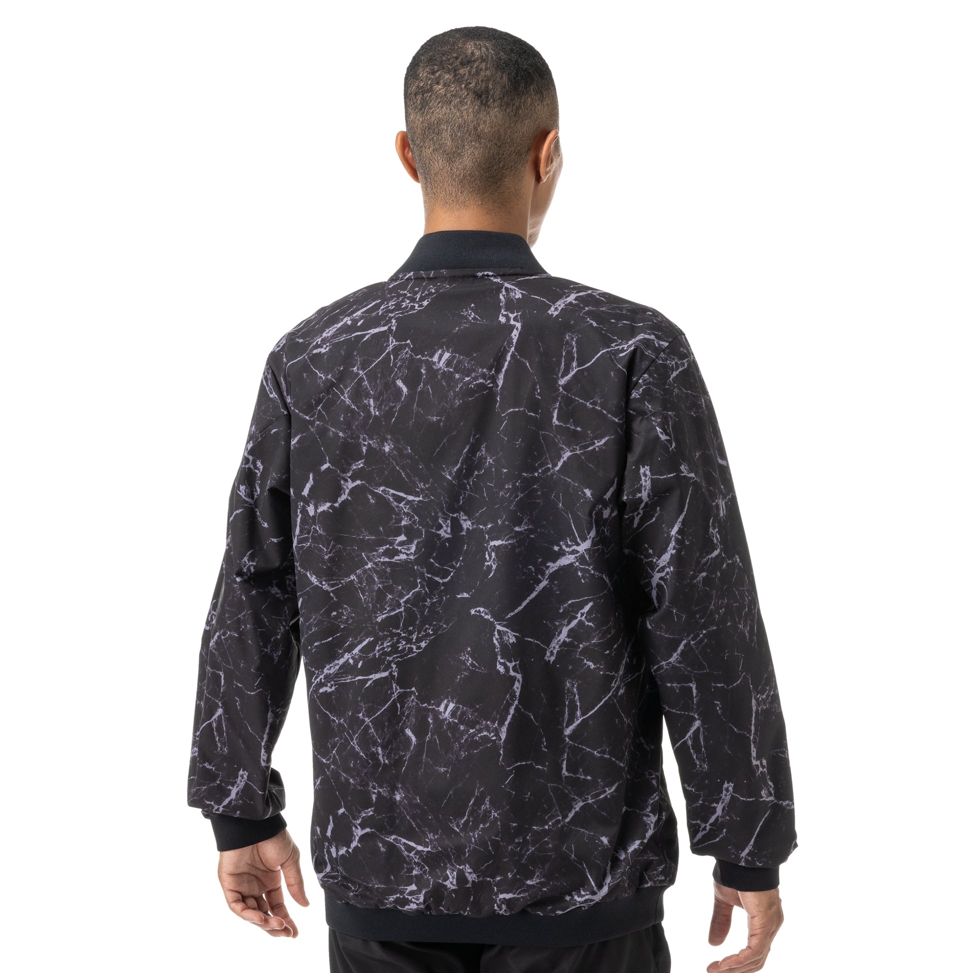 Man wearing a black and white patterned Yonex jersey on a white background