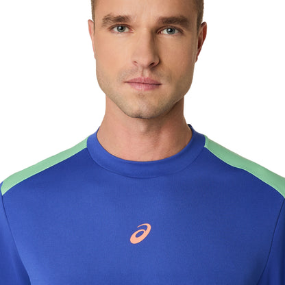 Man wearing a blue athletic shirt with a logo on a white background