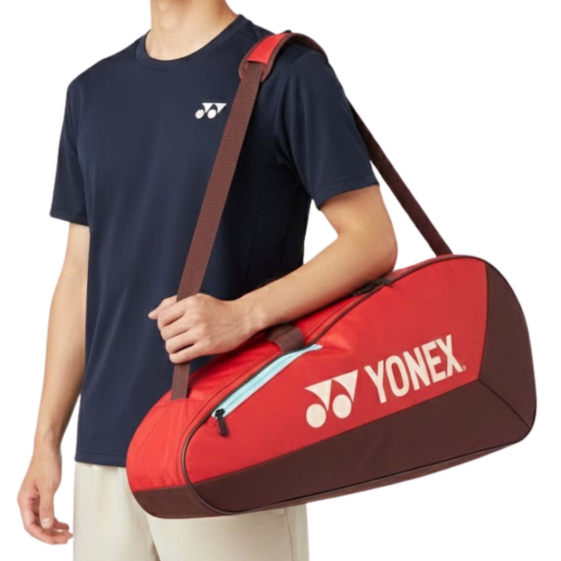 Person holding a red Yonex tennis bag with a white logo on a plain background