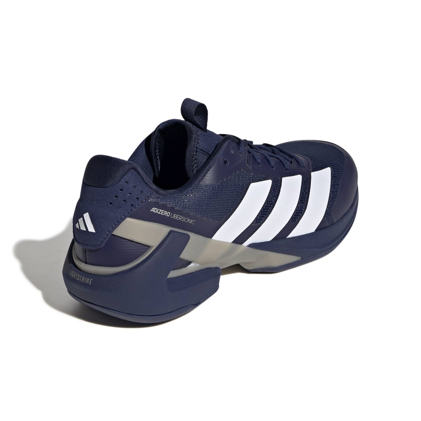 Navy blue Adidas shoe with white stripes on a white background