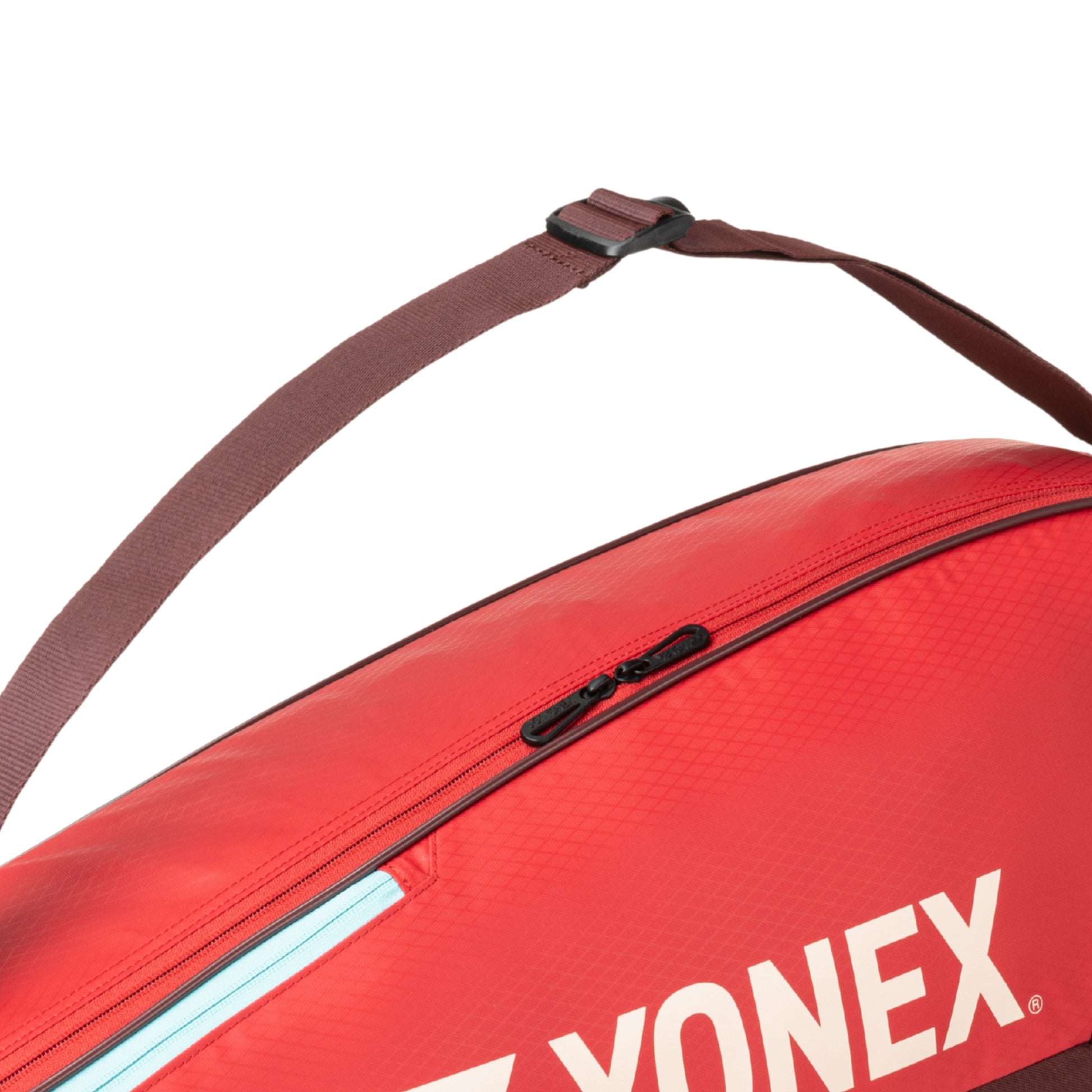 Red Yonex tennis bag with a strap on a white background