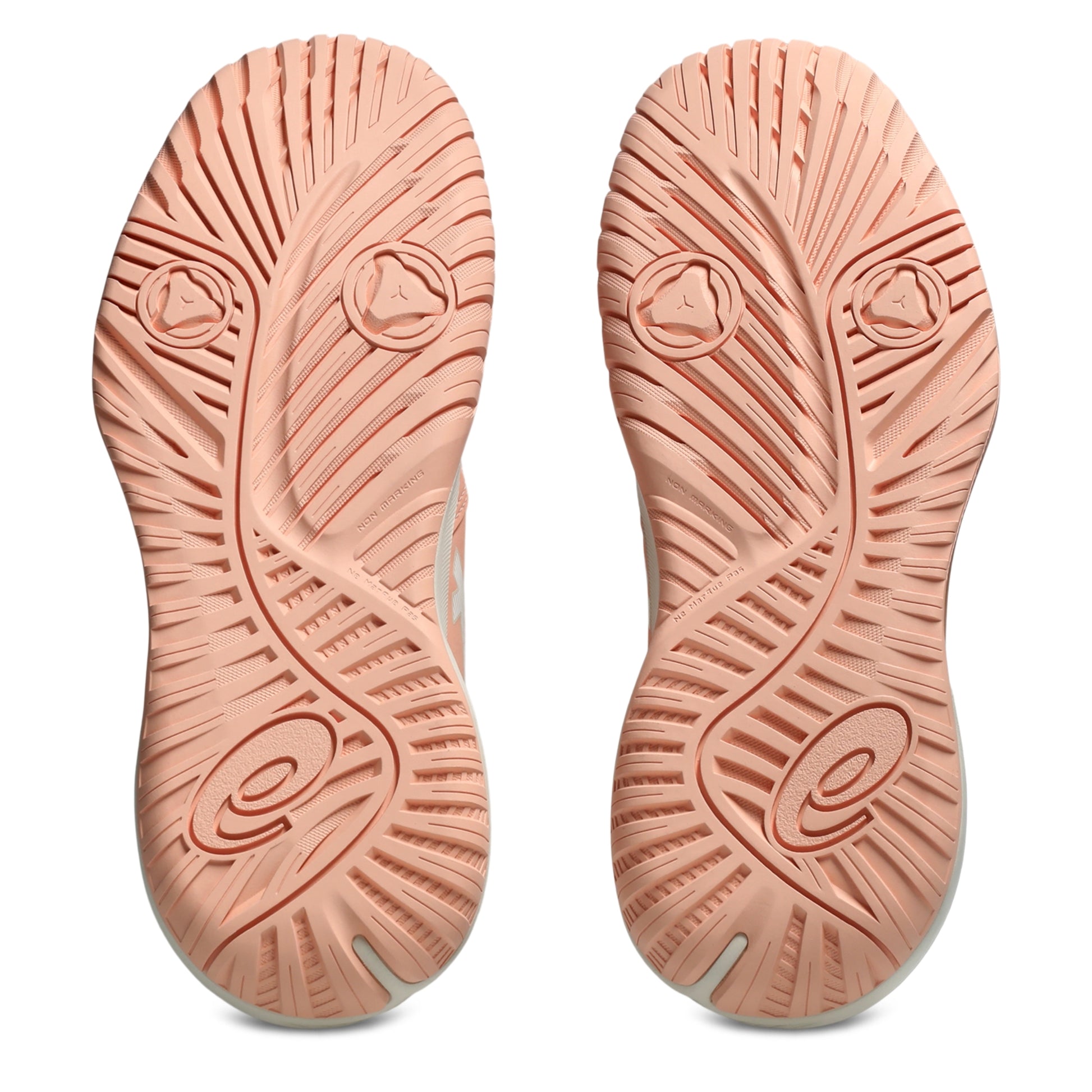 A pair of tennis shoes shown from the sole view, featuring a textured peach-pink rubber outsole with a wavy tread pattern and circular logo details on a white background.