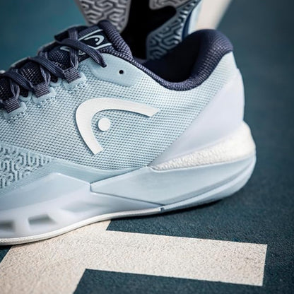 Light blue Head tennis shoe with a brand logo on a dark surface